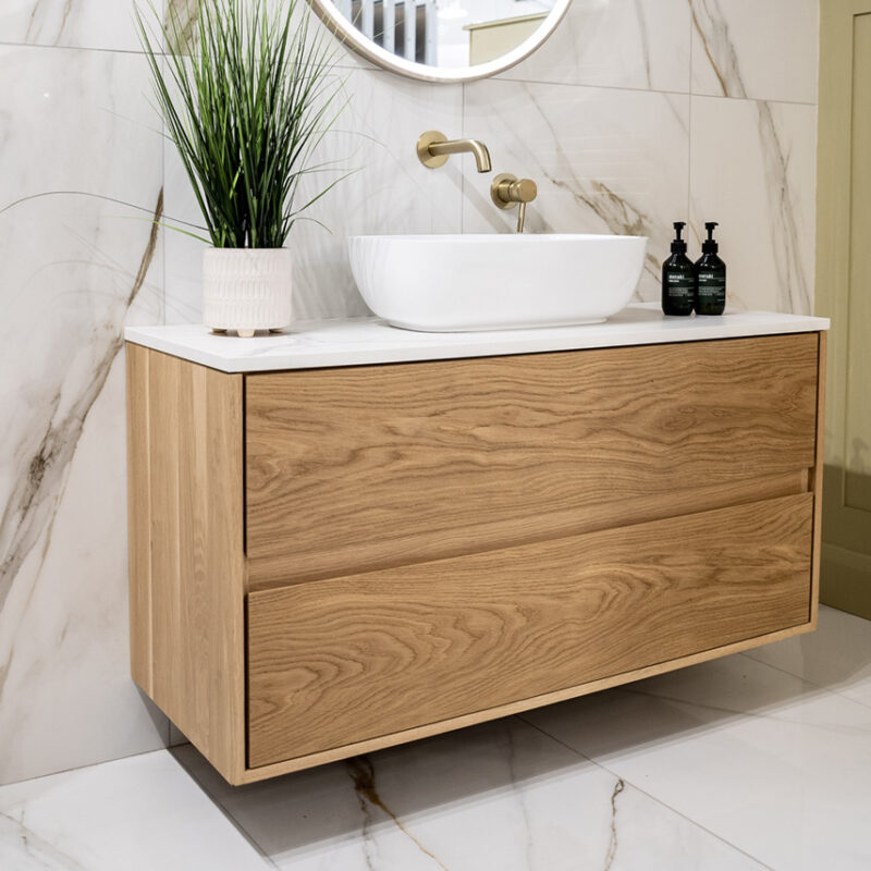 Bespoke oak vanity unit, custom-made to fit perfectly, complemented by luxurious gold-veined marble floor and wall tiles for an elegant finish