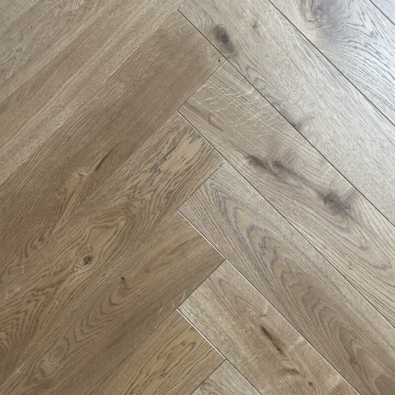 Walnut Transparent Oak Herringbone engineered timber flooring – rich walnut-toned oak planks in a classic herringbone pattern, featuring a transparent finish that highlights the natural wood grain and texture for a refined and elegant look