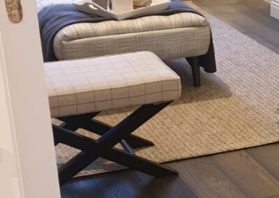 Dark oak charcoal engineered wood flooring in a modern living room with natural light, soft furnishings, and a neutral colour palette.