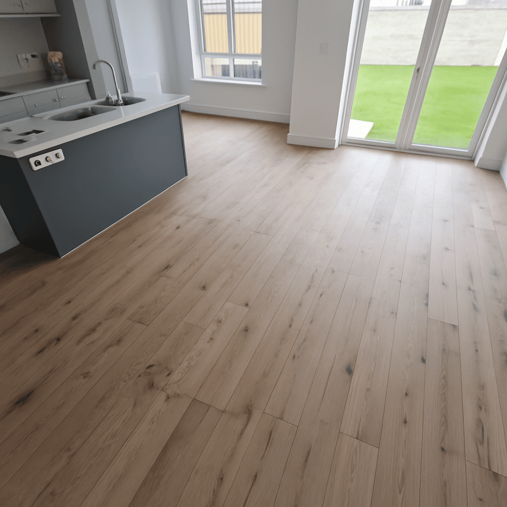 Medium oak bespoke engineered plank flooring in a bright modern kitchen with natural grain and warm brown tones.
